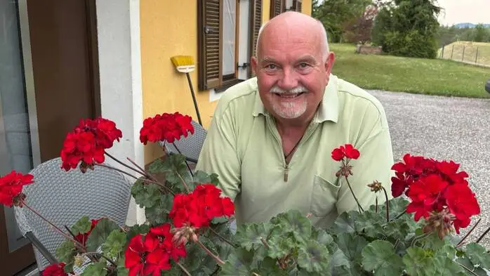Zu sehen ist ein Mann, der in die Kamera lacht