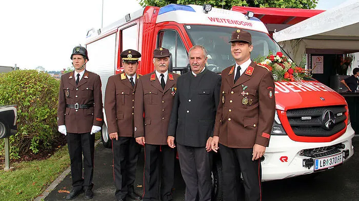 Vertreter von Feuerwehr und Gemeinde bei der Segnung des neuen Fahrzeuges