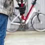 Eine Person mit Zange geht auf ein Fahrrad zu