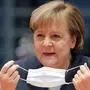 German Chancellor Angela Merkel holds a face mask as she attends the weekly cabinet meeting at the Chancellery in Berlin, Germany, Wednesday, Dec. 16, 2020. Germany has entered a harder lockdown, closing shops and schools in an effort to bring down stubbornly high new cases of the coronavirus. (Hannibal Hanschke/Pool Photo via AP)