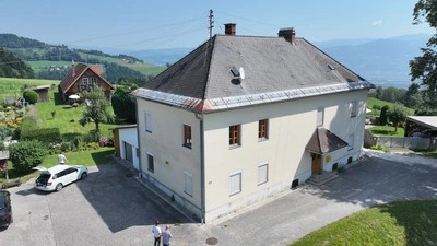 Ein weißes Wohngebäude mit grauem Dach 