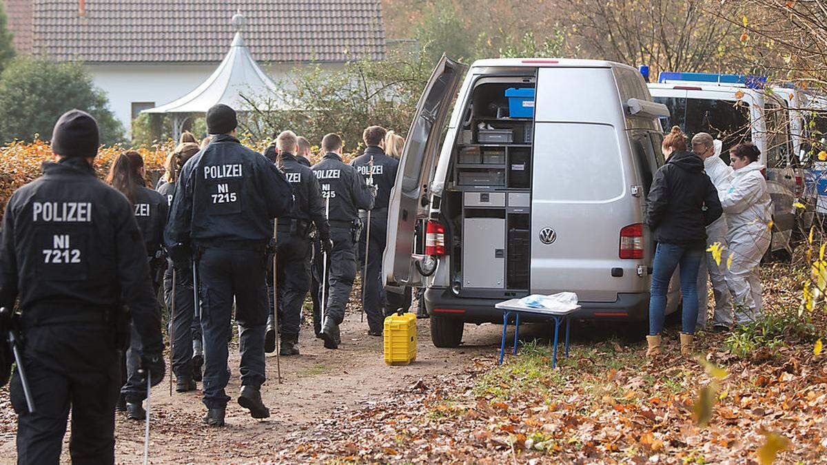 Polizisten suchen nach Spuren in einem Wald an einer Landstraße bei Celle 