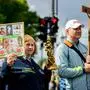 A protester displays a placard reading: "We love life" (L) as another one displays a crucifix during the annual anti-abortion "March for Life" demonstration in Berlin on September 17, 2022. (Photo by John MACDOUGALL / AFP)