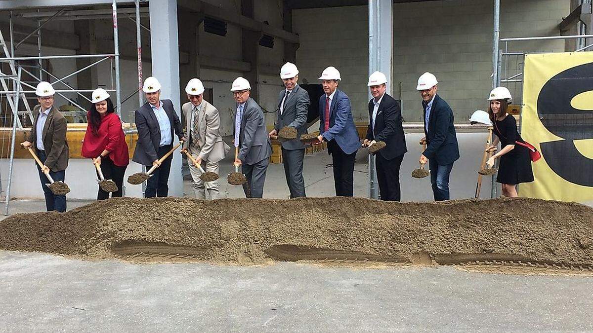 Spatenstich in den eigens angekarrten Sand, die Arbeiten am Gebäude sind ja schon im Gange