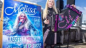 Melissa Naschenweng wird mit ihrer Band vor einer eindrucksvollen Bergkulisse auf der Bühne stehen