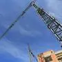 Tall swivelling crane on building site in front of a blue sky