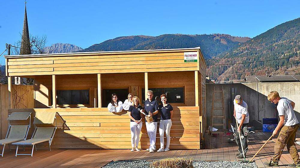 Während die letzten Bauarbeiten getätigt werden, ist das Hotelpersonal mit den Vorarbeiten zur Sauna-Eröffnung beschäftigt 	