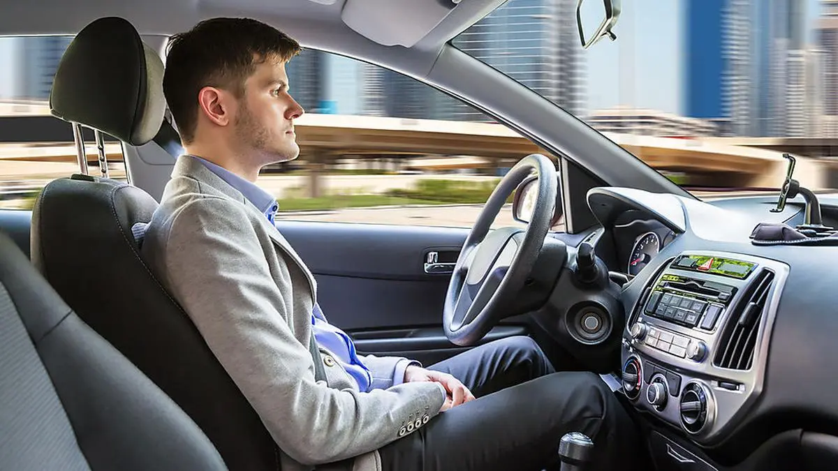Side View Of A Young Man Sitting Inside Autonomous Car
