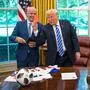 Donald Trump hält eine rote Karte in die Luft. Hinter ihm lacht Gianni Infantino. Die beiden befinden sich im Oval Office.
