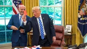 Donald Trump hält eine rote Karte in die Luft. Hinter ihm lacht Gianni Infantino. Die beiden befinden sich im Oval Office.