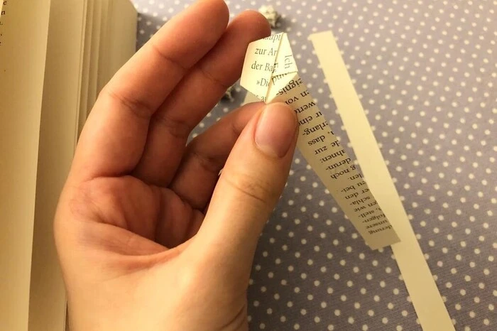 Das lange Stück Papier, das noch übrig ist, falte ich an die gegenüberliegende Seite meines Fünfecks.