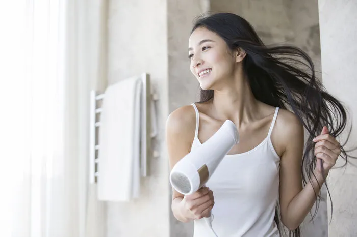 2. Einer der wichtigsten Schritte ist das Vorföhnen, das heißt die Haare zu etwa 80% vortrocknen, am besten mit kalter Luft. Wichtig dabei ist vor allem, dass man den Föhn zum Grund hält, nicht zu den Spitzen, denn sobald diese trocken sind, kann man sie nicht mehr formen. Das Vorföhnen am Grund erzeugt zudem mehr Volumen am Ansatz.