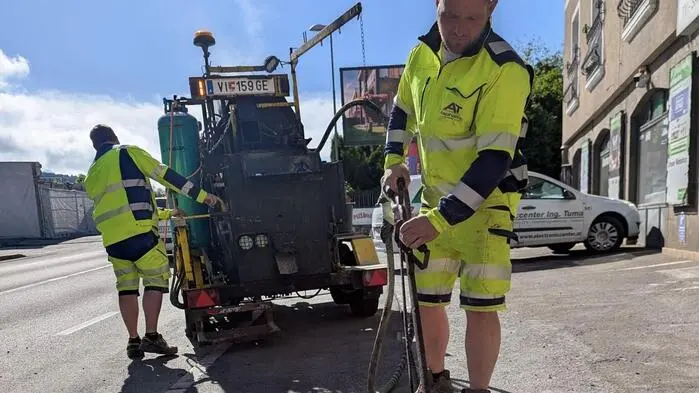 Man sieht Asphaltarbeiter bei der Arbeit