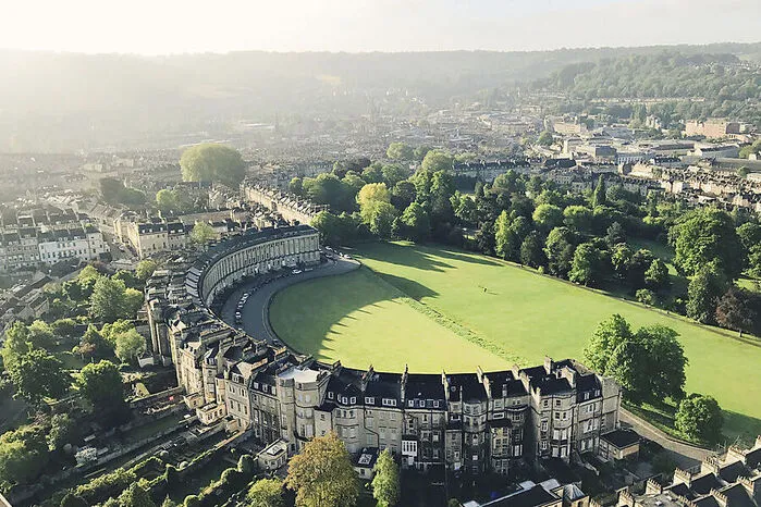 114 ionische Säulen zieren die perfekt symmetrischen Fronten der Royal Crescent, die in einem scharfen Kontrast zur Rückseite stehen – dort herrscht nämlich charmanter Wildwuchs. Gegenüber liegt der Royal Victoria Park: perfekt zum Flanieren im Bridgerton-Stil.