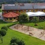 Blick auf Landgasthaus im Grünen, gelbe Fassade, Photovoltaik am Dach