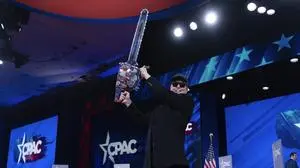 Elon Musk holds a chainsaw as he arrives to speak at the Conservative Political Action Conference, CPAC, at the Gaylord National Resort & Convention Center, Thursday, Feb. 20, 2025, in Oxon Hill, Md. (AP Photo/Jose Luis Magana)