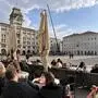 Das Bild zeigt Kaffeehausbesucher sitzend am Piazza Unità d‘Italia in Triest.