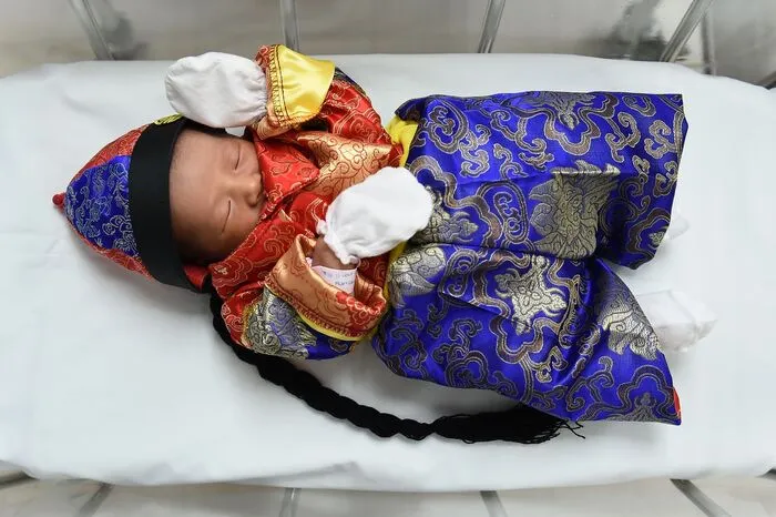Dieses Baby wurde in Bangkok geboren und in ein traditionelles chinesisches Kostüm gehüllt,...