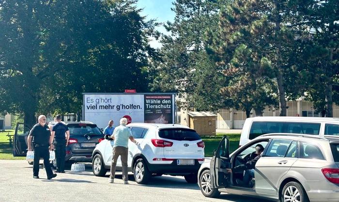 Autos fahren zur Wasserausgabe-Stelle