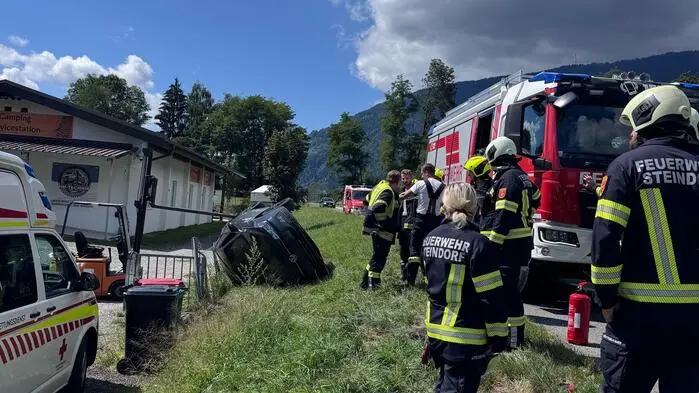 Man sieht das Unfallauto und Einsatzkräfte rundherum