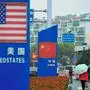 Signs with the US flag and Chinese flag are seen outside a store selling foreign goods in Qingdao in China's eastern Shandong province on September 19, 2018. - China on September 18 announced tariffs on US goods worth $60 billion in retaliation for President Donald Trump's decision to slap duties on $200 billion in Chinese products next week. (Photo by STR / AFP) / China OUT