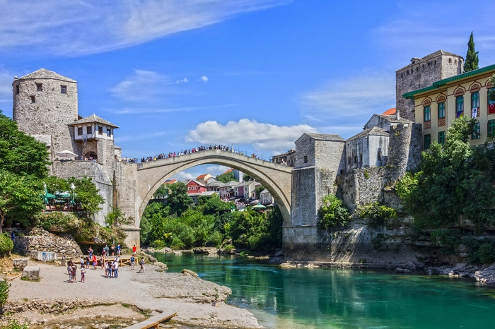 Mostar ist das kulturelle und politische Zentrum der Herzegowina. Die Steinbrücke, die hier über die Neretva führt, ist das wahrscheinlich am häufigsten fotografierte Wahrzeichen Bosniens. Von hier stürzen sich immer wieder waghalsige Klippenspringer – mittlerweile bevorzugt gegen Bezahlung von Touristen - in den 20 Meter darunterliegenden Fluss. Die „Alte Brücke“ (Stari Most) wurde während des Jugoslawienkriegs zerstört, seit 1996 rekonstruiert und 2005 zum UNESCO-Weltkulturerbe. Sie verbindet den christlichen mit dem muslimischen Teil der Stadt. Bei einem Spaziergang durch die engen Gassen des historischen Zentrums mit den vielen Steinhäusern, Handwerksläden und Cafés fühlt man sich wie in eine andere Zeit versetzt.