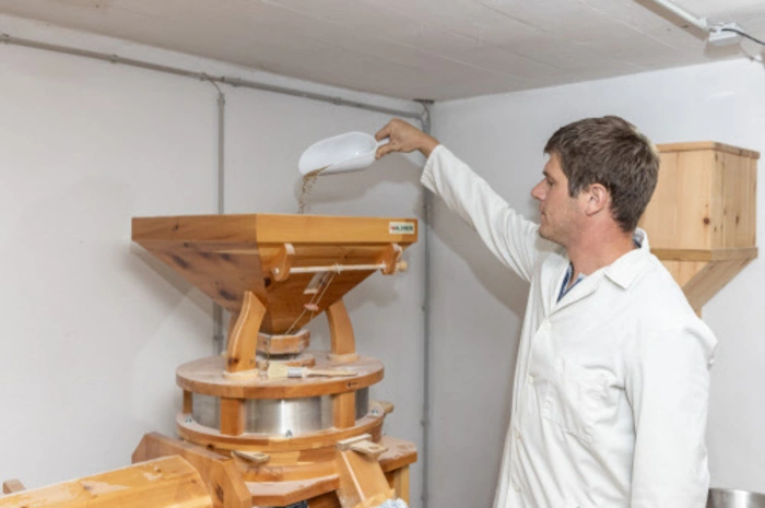 Franz Neuper beim Befüllen der Mühle mit Roggen