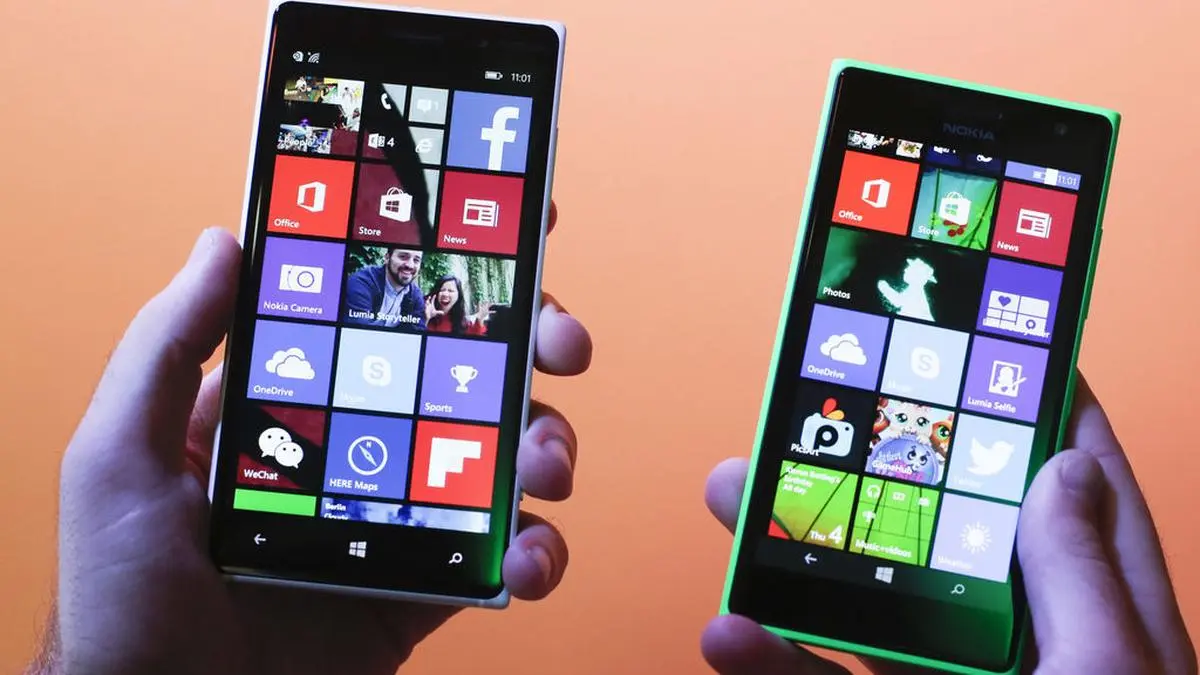 A man shows the new Lumia 830, left, and 730, right, smart phones during a Microsoft Nokia  presentation event at the consumer electronic fair IFA in Berlin, Thursday, Sept. 4, 2014. (AP Photo/Markus Schreiber)