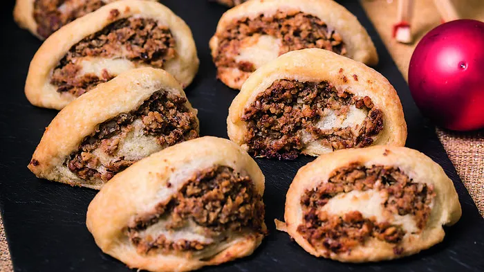 Nussiges Gebäck, in das man sich am liebsten reinlegen würde: Oberweger O'zwickte! Rezept: 600 Gramm Mehl und 500 Gramm kalte, blättrig geschnittene Butter abbröseln. 250 Gramm Sauerrahm, vier Eidotter, 100 ml Weißwein und eine Prise Salz kneten. Teig abdecken und einige Stunden (am besten über Nacht) im Kühlschrank rasten lassen. Für die Fülle 800 Gramm geriebene Walnüsse (oder Haselnüsse), 140 Gramm Kristallzucker, zwei Packungen Vanillezucker, zwei Esslöffel Honig, vier Esslöffel Powidl (oder Marillenmarmelade), zwei Stamperl Rum (oder Schnaps), 250 ml warme Milch, 160 Gramm zerlassene Butter und zwei Messerspitzen verrühren, bis die Masse gut streichfähig ist. Den Teig rechteckig in Strudelform auswalken (nicht zu dünn, ca. 15 cm breit und 3 mm dick). Mit Fülle gleichmäßig bestreichen, zusammenrollen und den Teig mit zwei verquirlten Eiern bestreichen. Mit einem Kochlöffel oder besser mit einem runden Keksausstecher ca. 2,5 cm große Struderln "o'zwickn" (abzwicken). Im vorgeheizten Backrohr bei 170-180 °C (Heißluft) ca. 30 bis 35 Minuten backen. Abkühlen lassen und mit Staubzucker bestreuen. (Rezept von Leser Herbert Marak)
