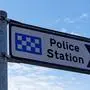 A signpost indicates the police station in United Kingdom
