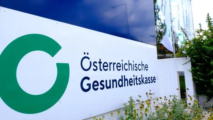 Schriftzug „Österreichische Gesundheitskasse“ und Logo: ein grüner Kreis, der kurz unterbrochen ist und damit sowohl als O als auch als G gelesen werden kann