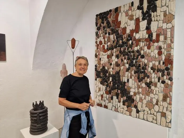 Elisabeth Raunig vor ihrem variablen Kunstwerk mit kleinen Tonköpfen
