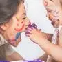 Happy mom and baby playing with painted face by paint. Mother day. Games with child affect early development. Important to spend enough time with your kids.
