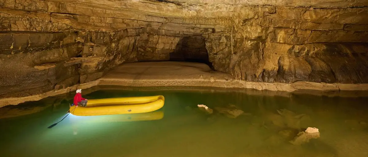 Ein See in einer Höhle, auf dem ein Schlauchboot fährt