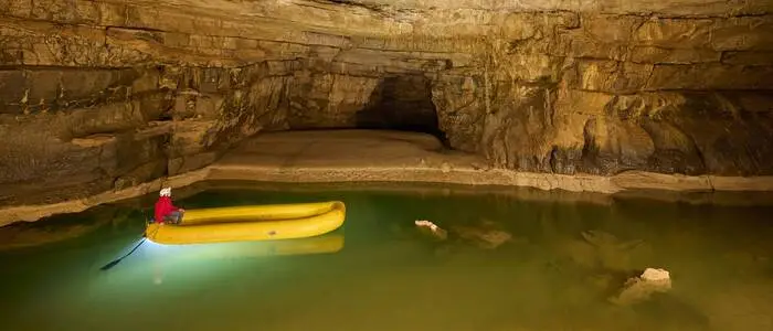 Ein See in einer Höhle, auf dem ein Schlauchboot fährt