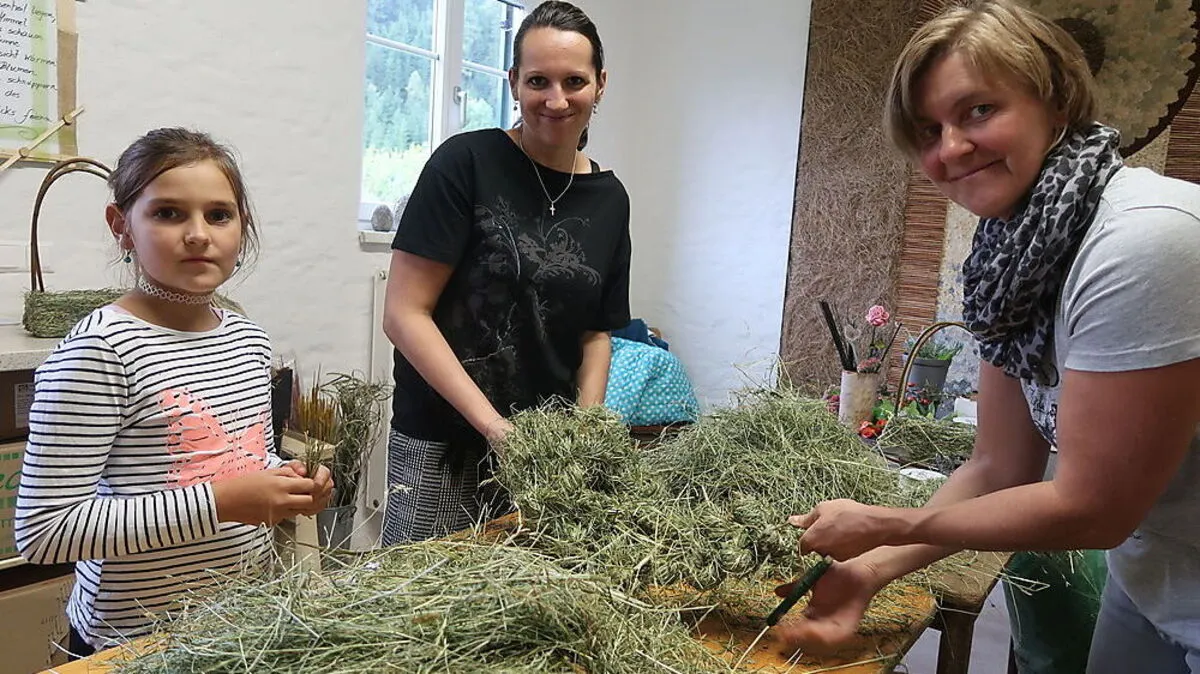 Sophia hat mit ihrer Mutter Julia Willingshofer und Floristin Margarete Hochreiter (rechts) mit dem Heu gearbeitet