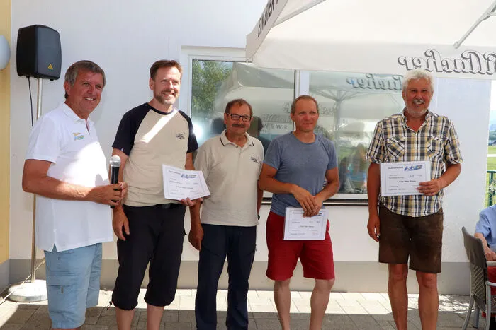 Sieger in der 107er Klasse mit Martin Huber von Links:2. Platz: Supersperger &amp; Derntl (Doppelsitzer) 5.424 Punkte. 1. Platz: David Richter Trummer 5.469 Punkte3. Platz: Friedrich Hofinger 5.344 Punkte Ergebnisliste 107-er Klasse:https://www.soaringspot.com/de/aac2021/results/107er  