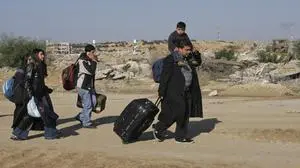 Christian Palestinians carry their belongings to the Erez Crossing between the northern Gaza Strip and Israel, on their way to attend Christmas celebrations in the West Bank town of Bethlehem, Monday, Dec. 24, 2007. About 3,000 Christians live in Gaza, an overwhelmingly conservative Muslim territory of 1.5 million people. (AP Photo/Hatem Moussa)
