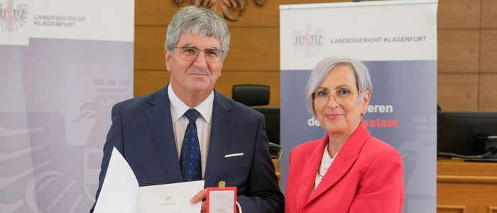 Zwei Personen halten eine Auszeichnung in der Hand