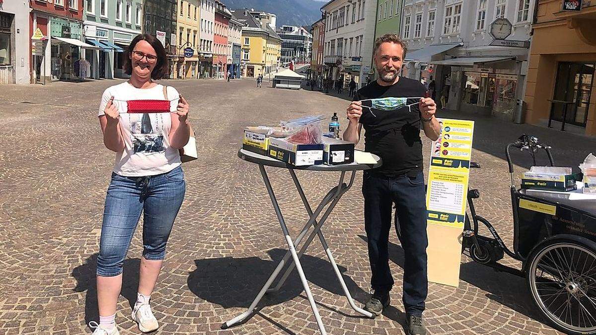 Susanne Schlattery freut sich über ihre neuen Masken, die City-Bote Georg Moser am Hauptplatz für die Villacher Betriebe verkauft. 