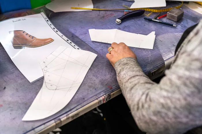 In der Näherei wird ein Schnittmuster für einen Schuhschaft gezeichnet.