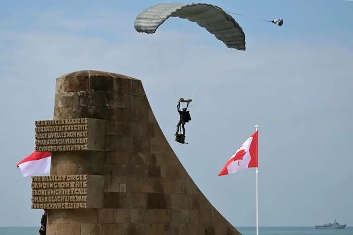 A parachutist prepares to land during the International commemorative ceremony at Omaha Beach marking the 80th anniversary of the World War II "D-Day" Allied landings in Normandy, in Saint-Laurent-sur-Mer, in northwestern France, on June 6, 2024. The D-Day ceremonies on June 6 this year mark the 80th anniversary since the launch of 'Operation Overlord', a vast military operation by Allied forces in Normandy, which turned the tide of World War II, eventually leading to the liberation of occupied France and the end of the war against Nazi Germany. (Photo by MIGUEL MEDINA / AFP)