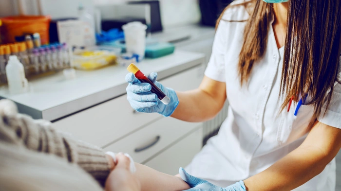 Patient wird von Ärztin Blut abgenommen
