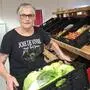 Eine Frau mit einer Kiste voll Salat in der Hand
