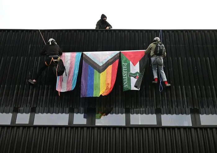 Zwei Aktivisten hatten sich beim Eingang der Messehalle unter anderem mit einer Regenbogenfahne und einer Palästina-Flagge vom Dach abgeseilt
