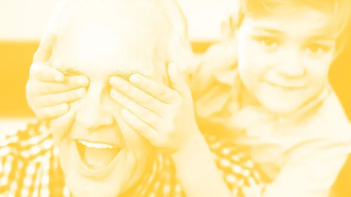 Happy senior man and little boy covering his eyes