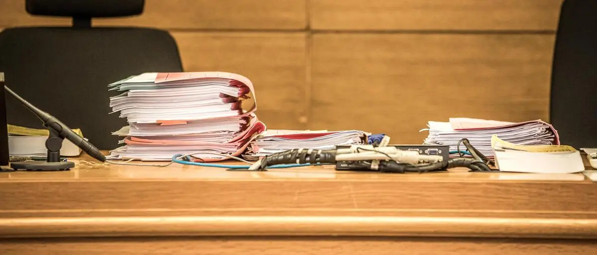 Aktenordner mit Akten liegen auf einem Richtertisch bereit