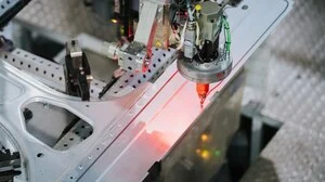 Automatisierte Präzisionsarbeit: Ein Roboter trägt Klebstoff an einer Fahrzeugkarosserie auf | Automatisierte Präzisionsarbeit: Ein Roboter trägt Klebstoff an einer Fahrzeugkarosserie auf