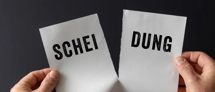 Zettel mit dem Wort „Scheidung“ wird auseinandergerissen.