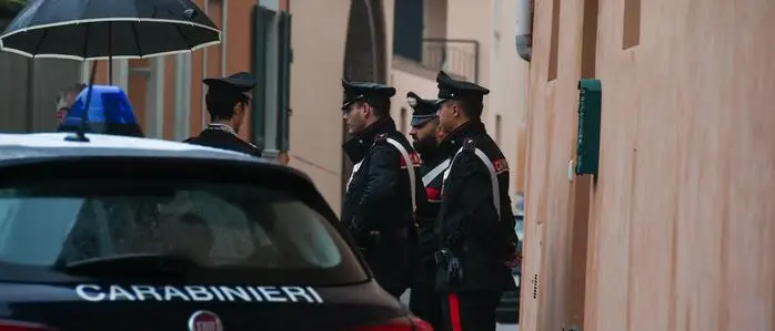 Man sieht ein Auto und Einsatzkräfte der Carabinieri